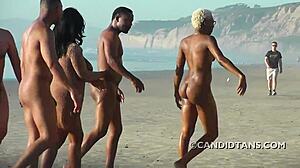 Pareja interracial tetona disfruta de la desnudez en la playa